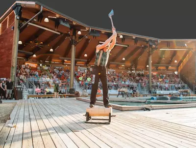 audience watches while lumberjack chops