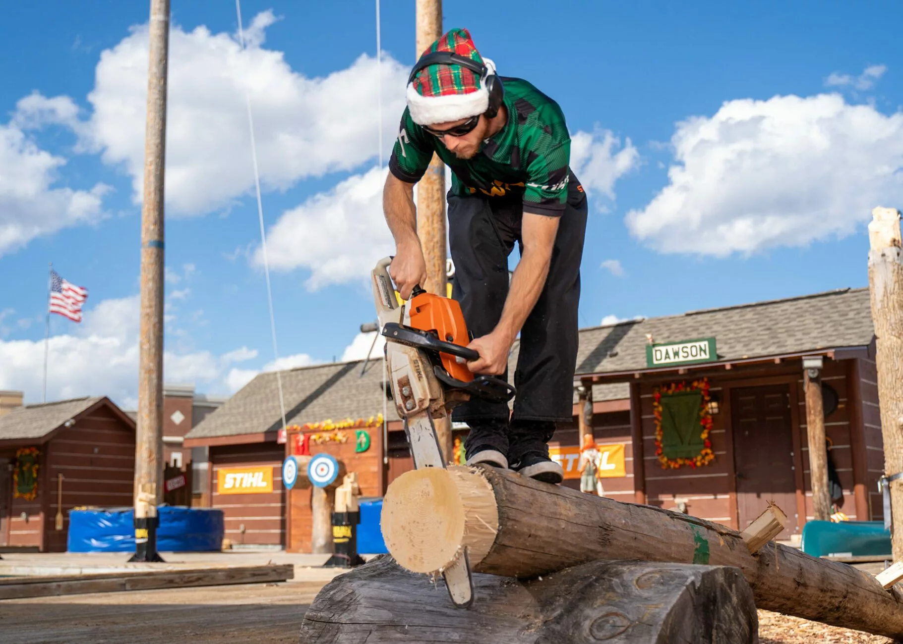 Lumberjack sawing a log during Christmas show