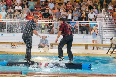 lumberjacks competing at log rolling at paula deen's lumberjack feud